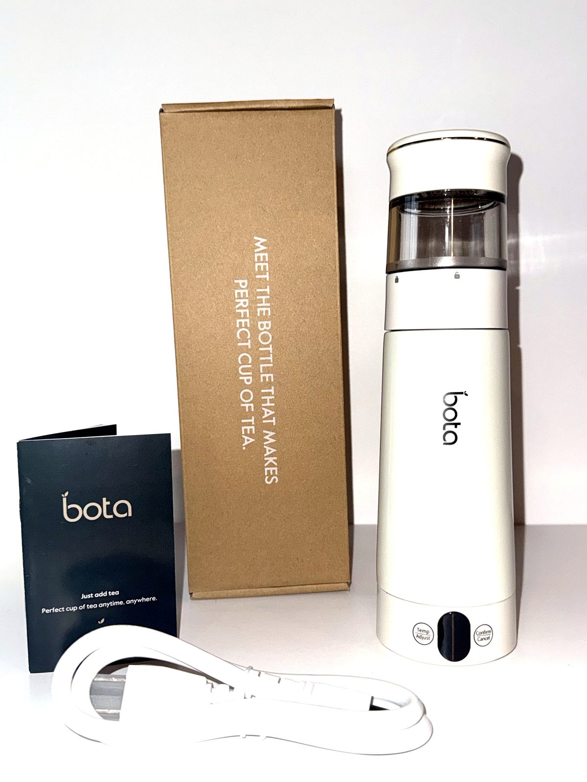 The bottle beside its retail box, printed card and detachable power cord